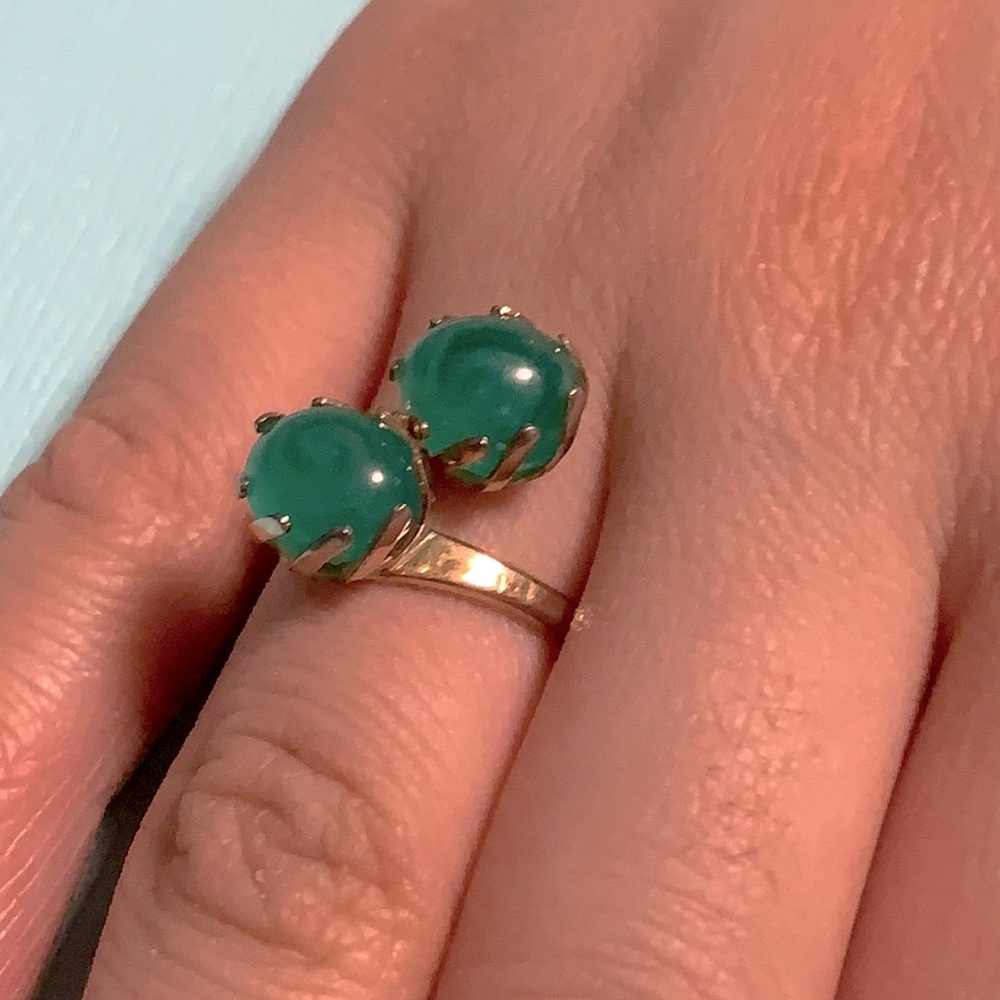 Cosmetic gold tone ring with green stones